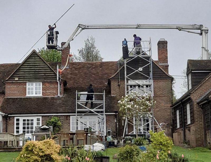 The Moss Cleaners using cherry picker and scaffolding to clean roof safely and professionally in Romsey, Hampshire
